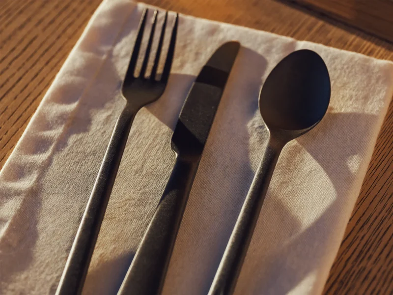 Set de tacâmuri mat negru cu mânere subțiri pe pânză de in